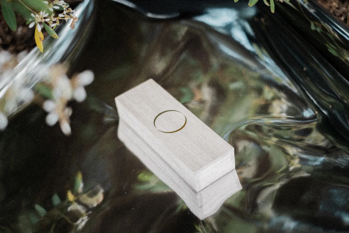 Paulownia box resting on dark, rippling water